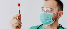 врач с пробиркой крови для анализа